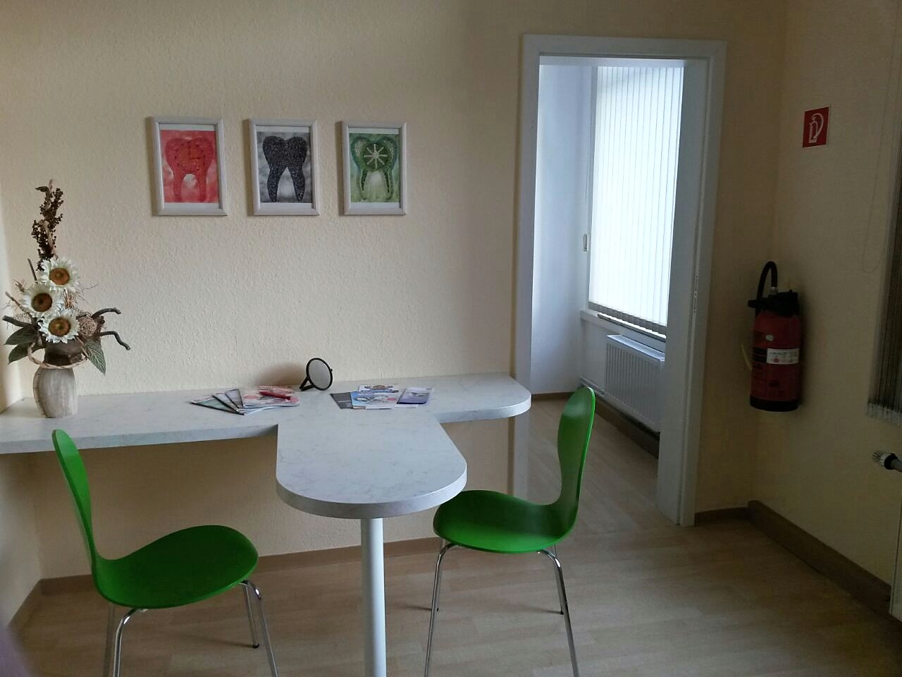 Beratungsraum mit Tisch und grünen Stühlen